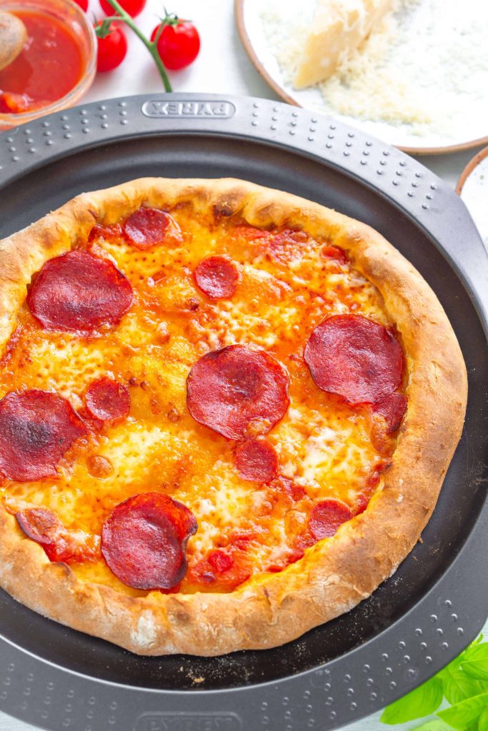 pepperoni pizza on an oven tray cooked