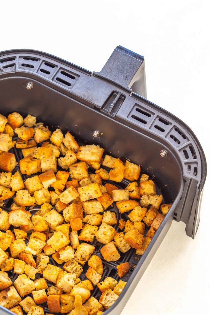 cooked croutons in an air fryer basket